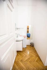uma casa de banho com um lavatório branco e piso em madeira em Center apartment 5 private room for 19 people em Budapeste