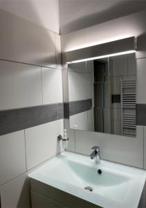Baño blanco con lavabo y espejo en Apartment Wien Mitte, en Viena