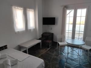 Cette chambre blanche comprend un lit, une table et des chaises. dans l'établissement Kea Island, à Korissia