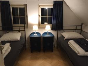 twee bedden in een kamer met twee lampen op tafels bij Vakantiehuis Villa 56 in Heel