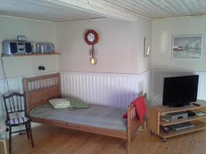 1 dormitorio pequeño con 1 cama y TV en Fjättramåla Apartment, en Fagereke