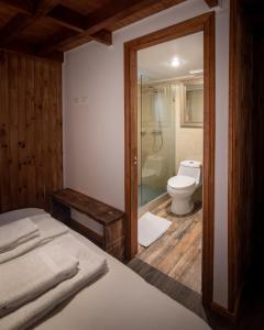 uma casa de banho com uma cama, um chuveiro e um WC. em HOTEL VOLKANICO em Curacautín