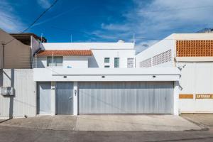 een wit huis met een garage bij Departamento Reforma in Oaxaca City