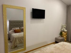 espejo en un dormitorio con cama y TV en Casinha da Eira, en Esposende