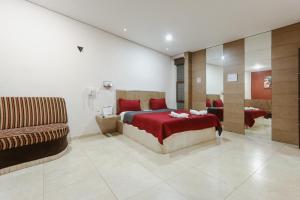 1 dormitorio con cama roja y sofá en Auto Hotel Las Maravillas, en Santa Cruz Xoxocotlán