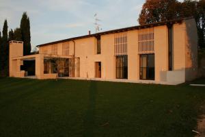 a large building with a grass field in front of it at Brick house in Sommacampagna