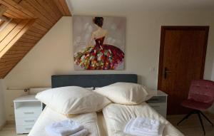 RemptendorfにあるRomantische Ferienwohnung Metznerのベッドルーム1室(壁に絵画が描かれたベッド1台付)