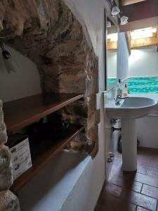 a bathroom with a sink and a stone wall at Cà Feddia in Bagnone