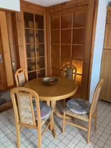 a dining room with a wooden table and chairs at Romantische Ferienwohnung Metzner in Remptendorf