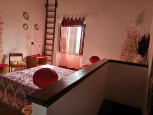 a bedroom with a bed with red chairs and a window at Cà Feddia in Bagnone