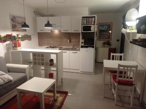 cocina y sala de estar con sofá y mesa en villa verde bed and breakfast en Uggiate