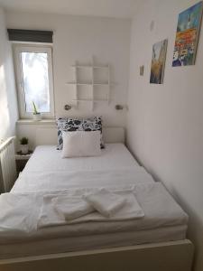 a white bed in a room with a window at Studio Apartment TIM in Zagreb