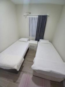 two beds in a small room with a window at Yaz kış güzel manzaralı ev in Bodrum City