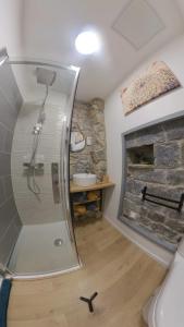 a bathroom with a shower and a stone fireplace at studio entre terre et ciel - escapade millavoise in Millau