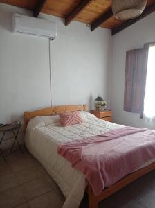 1 dormitorio con 1 cama con manta rosa en La cuarta en Baradero