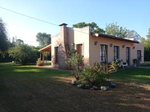 una pequeña casa blanca con patio en La cuarta en Baradero