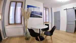 Zimmer mit Tisch, Stühlen und Vase in der Unterkunft studio entre terre et ciel - escapade millavoise in Millau