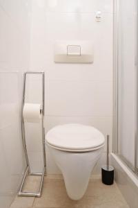 a white toilet in a bathroom with a toilet paper holder at Heart of Vienna, First district in Vienna