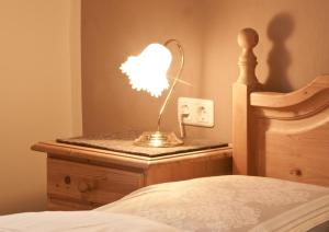 una lámpara sentada en una mesita de noche junto a una cama en Landhaus Tyrol, en Mayrhofen