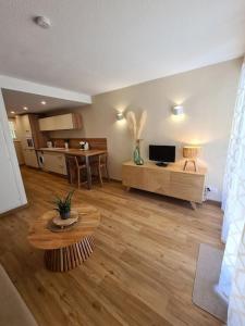 sala de estar con sofá, mesa y cocina en Appartement au calme dans residence avec piscine, en Boersch