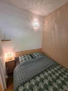 1 dormitorio con 1 cama y una luz en la pared en Appartement au calme dans residence avec piscine, en Boersch