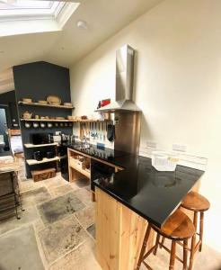 a kitchen with a black counter top in a room at The Watchmakers Matlock in Matlock