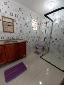 La salle de bains est pourvue d'une douche, d'un lavabo et de toilettes. dans l'établissement Chácara Helenna Colonetti, à Lindóia