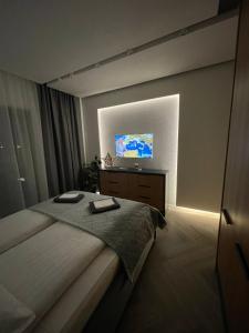 ein Schlafzimmer mit einem Bett und einem TV an der Wand in der Unterkunft Luxury by The Lake Ap 25 in Sibiu