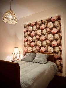 a bedroom with a wall covered in pink roses at Petit prince chambre à louer in Saint Die