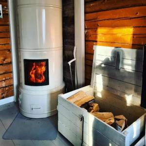 a woodburning stove in a cabin with a stove at Ainutlaatuinen huoneisto Vanhassa kyläkoulussa 