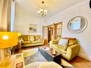 a living room with two couches and a table at Four-tunes just 2 mins walk from Torquay harbour in Torquay