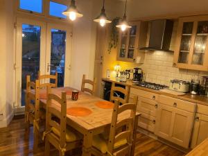 a kitchen with a wooden table and chairs in it at Four-tunes just 2 mins walk from Torquay harbour in Torquay
