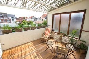 un patio con tavolo e sedie sul balcone. di Ruim, lichtrijk appartement met terras in centrum a De Haan