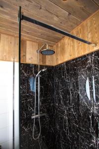 a shower in a bathroom with a black counter top at Ruim, lichtrijk appartement met terras in centrum in De Haan