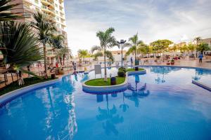 a large swimming pool with blue water and palm trees at Riviera Park in Caldas Novas