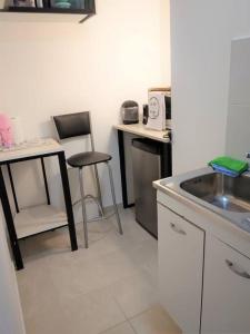 uma cozinha com um lavatório, uma mesa e cadeiras em Ubicación ideal en Ciudad de Neuquén. em Neuquén