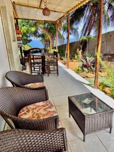 um pátio com cadeiras de vime e uma mesa e uma mesa e cadeiras em Mar de Vênus em Fernando de Noronha