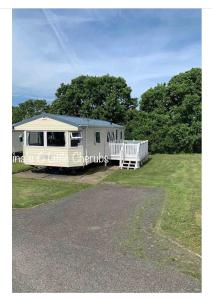 a mobile home with a fence and a yard at 3 bedroom holiday home in Thorness bay in Cowes