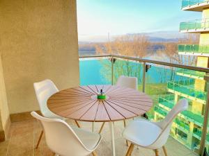 a table with chairs and an umbrella on a balcony at Marina Panorama Apartment & Garage in Budapest