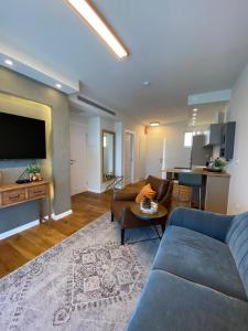 a living room with a blue couch and a table at neot golf kz place in Caesarea