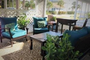 um pátio com cadeiras e uma mesa e uma mesa e cadeiras em Seahorse Bungalow em St Pete Beach