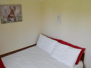 uma cama com lençóis brancos e uma foto de um coelho em Olive - Uk12694 em Stalham