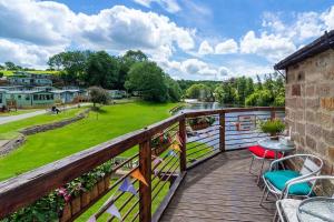 einen Balkon mit einem Tisch, Stühlen und einem Fluss in der Unterkunft Leylandii 2 Bed Holiday Home in picturesque town. in Knaresborough