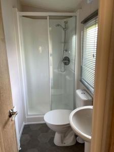ein Bad mit einer Dusche, einem WC und einem Waschbecken in der Unterkunft Leylandii 2 Bed Holiday Home in picturesque town. in Knaresborough