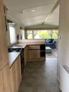 a small kitchen with a stove and a couch at Leylandii 2 Bed Holiday Home in picturesque town. in Knaresborough