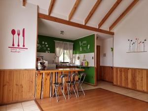 cocina con encimera de madera y pared verde en La Casa del Árbol Villarrica Cabañas-Piscina-Tinajas, en Villarrica