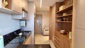 a kitchen with a counter and a stove top oven at Flat de Luxo c/ Quarto Privativo 21º Andar Vertigo in Campo Grande