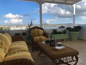 a patio with two couches and a table and a view at Celia in Adamas