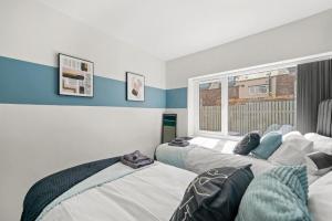 ein Schlafzimmer mit zwei Betten und einem Fenster in der Unterkunft Sleek 3 bedroom in Sheffield - Sleeps 8 in Wincobank