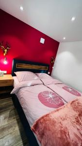 una camera con una parete rossa e un letto di Alpenjuwel a Scheidegg
